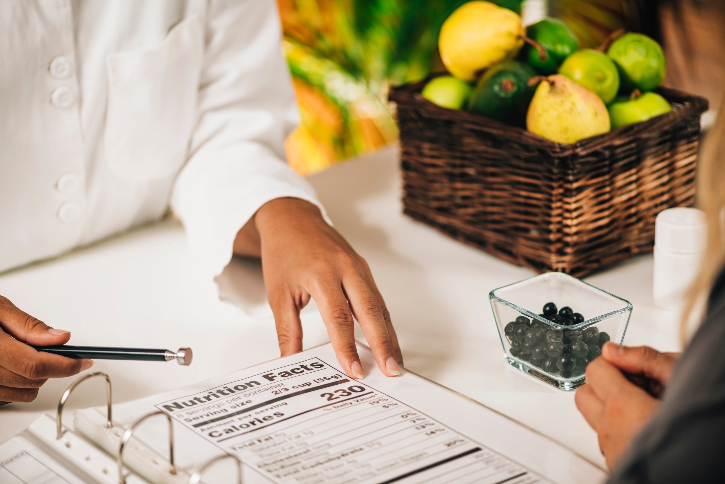 Nutritionist Explaining Nutrition Facts Label To A Client, Close-Up